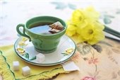 tea - tea cup - saucer - daffodils - sugar cubes - floral table cloth