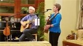Blumora Folk singers in concert (man and woman playing guitar)