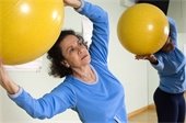 Women using exercise balls in fitness class.