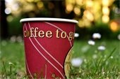 "Coffee to Go" - paper coffee cup - steam - on grass outside