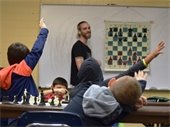 Students raising their hand in a chess class