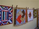 Quilts hanging on wall.