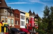Washington, DC, neighborhood with colorful buildings, businesses, diverse national flags and murals.