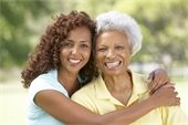 African-American mother & daughter smiling and hugging.