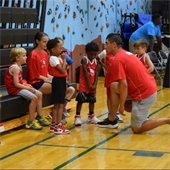 Coach talking to youth players on bench
