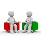 Two silhouette figures sitting in chairs talking.