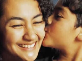 Small boy kissing a woman on the cheek