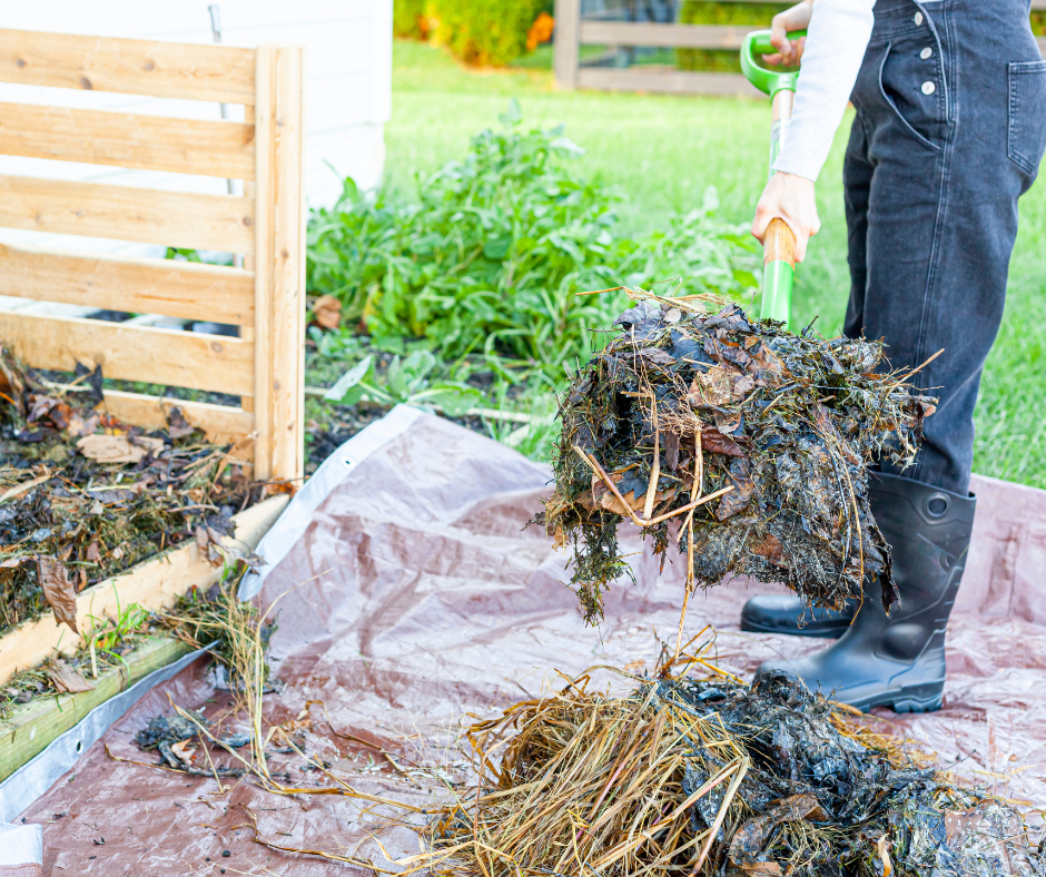A person turning a compost pile